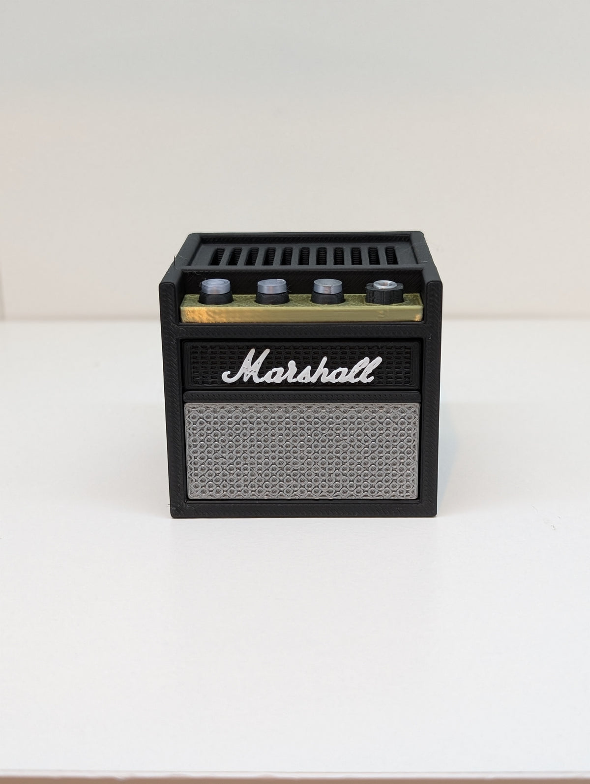 Front of the 3D printed mini guitar amp pick holder on a white shelf