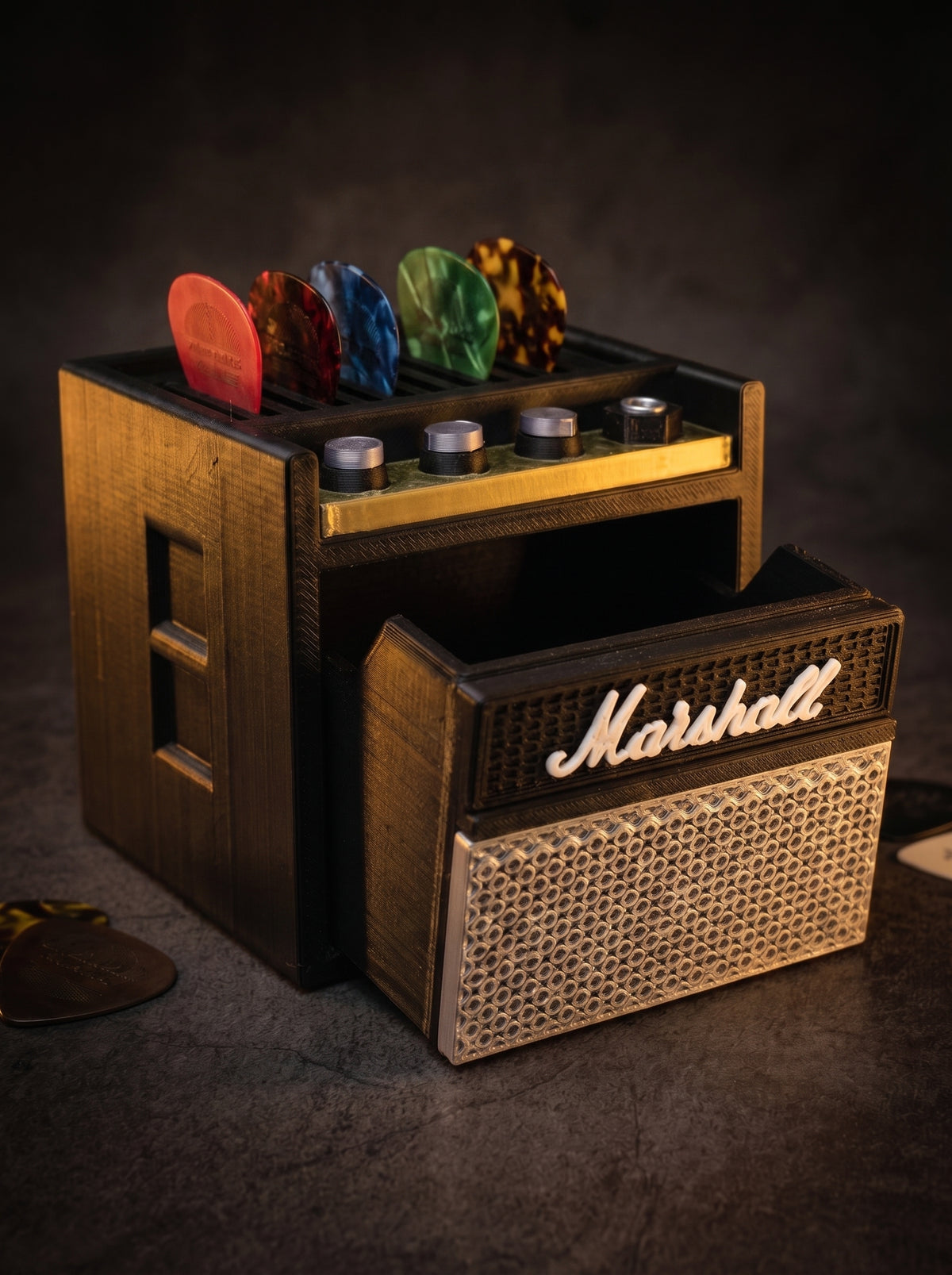 Mini guitar amp pick holder with picks on top and the storage drawer pulled out