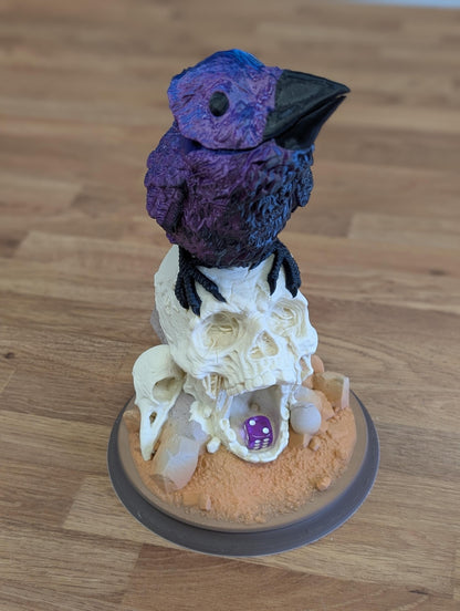 Full Colour raven dice tower from the front: blue and purple silk raven on a bone white skull