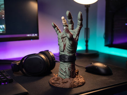 Empty zombie hand controller holder on a gaming desk at night with purple and teal lights